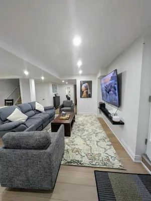 a living room with a couch and a tv at Studio 8848 - Sleeps 8 in Brampton