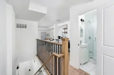 a white bathroom with a staircase and a shower at Chic 3BR Ossington Hub Near Subway & Shops in Toronto