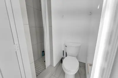 a bathroom with a white toilet in a room at Guestic at Queen West in Toronto
