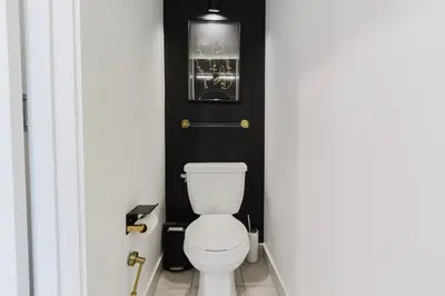 a white toilet in a bathroom with a black wall at Luxury Elegant Full house Escape Premium Comfort in Mississauga