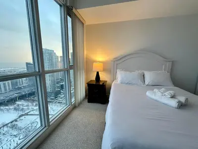 a bedroom with a white bed and a large window at Dreamspace 3 Bdrms with 1 Parking in Toronto