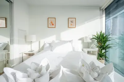 a bedroom with a white bed with flowers on it at Stunning Lake and CN Tower View with 2BR 2BA Free Parking in Toronto