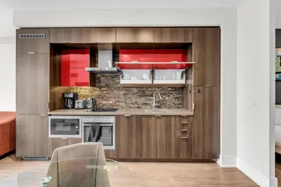 a kitchen with wooden cabinets and a sink at Eleve Toronto Residences in Toronto