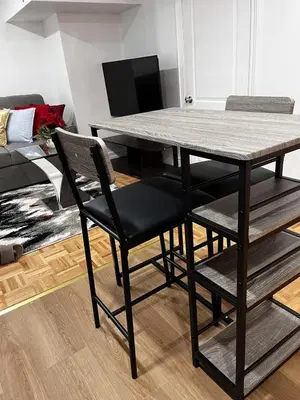 a dining table and chairs in a living room at Brand New Comfortable and Cozy Apartment near the Airport in Toronto