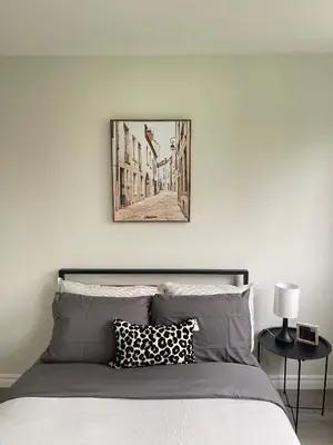 a bedroom with a bed with a picture on the wall at Hamilton Haven Private Rooms in Hamilton