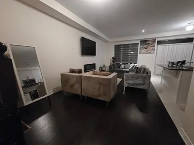 a living room with two chairs and a couch at Elegant 3BR Kleinburg Townhouse Free Parking Wifi Full Kitchen Laundry Near Canadas Wonderland in Vaughan