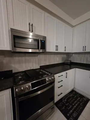 a kitchen with a stove and a microwave at Elegant 3BR Kleinburg Townhouse Free Parking Wifi Full Kitchen Laundry Near Canadas Wonderland in Vaughan
