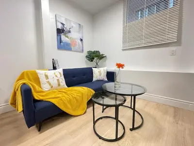 a living room with a blue couch and a table at The Scholar Suite Modern Comfort Near Western U in London