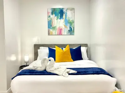 two swans towels are sitting on a bed at The Scholar Suite Modern Comfort Near Western U in London