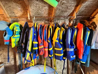 a bunch of umbrellas are hanging on a rack at Rustic and Spacious Lakefront Oasis in Nature in Algonquin Highlands