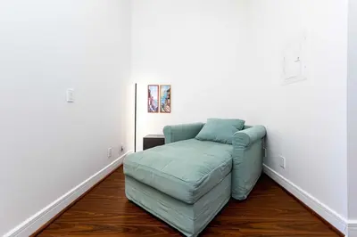 a blue couch in a room with white walls at Luxury 1BR Plus Den Condo With Sauna Access in Toronto