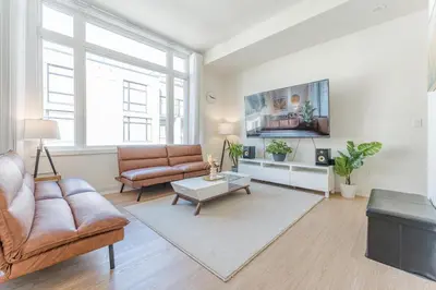 a living room with a couch and a table at Modern Family Townhouse 2 Bedrooms 3 Full Bathrooms Sleeps 6 in Richmond Hill