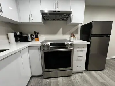 a kitchen with a stove and a refrigerator at Beautiful Newly Built 2 Bedrooms Basement Apartment in Milton ,Sleeps 6 in Milton