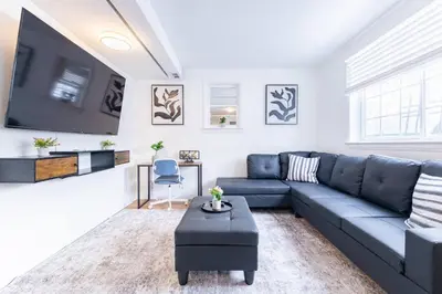 a living room with a blue couch and a tv at 2min to DT, Cowboys, Full-Kitchen, 65 inch TV in London