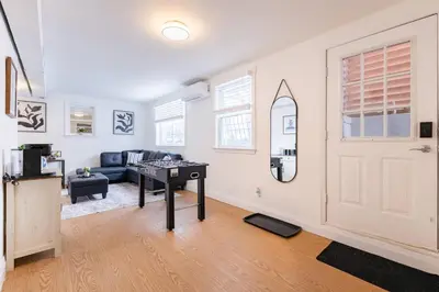a living room with a couch and a door at 2min to DT, Cowboys, Full-Kitchen, 65 inch TV in London