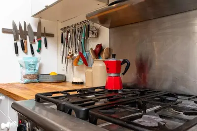 a kitchen with a stove with a red pitcher on it at Spacious 3 Bedroom Toronto Home with Piano in Toronto