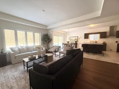 a living room with couches and a kitchen at Serene Escape Near Niagara Falls - Premium in Thorold
