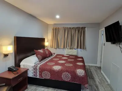 a hotel room with a bed and a television at Cobourg Inn in Cobourg