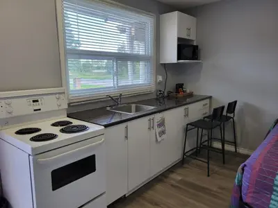 a kitchen with a white stove and a sink at Cobourg Inn in Cobourg