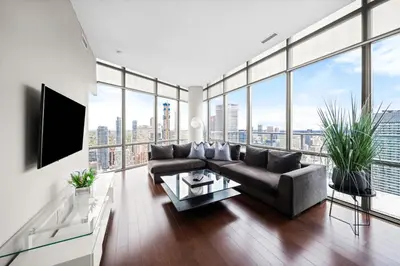 a living room with a couch and a large window at Lux Penthouse Retreat Near Yorkville with Parking in Toronto