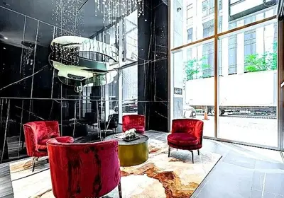 a room with red chairs and a table in a building at Luxury Yorkville Two Bedroom Condo With Views and Parking in Toronto