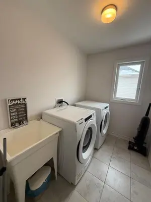 a bathroom with two washing machines and a sink at Charming Short-Term Stay Near Downtown Fergus & Elora Mill in Fergus