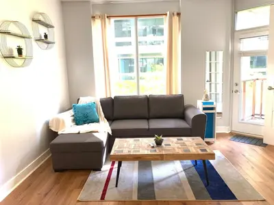 a living room with a couch and a coffee table at Bloor Yonge Cozy 1BR And Den Free Parking in Toronto