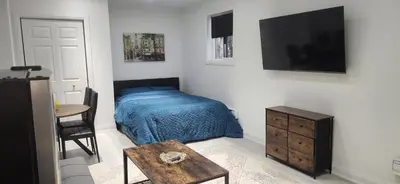 a bedroom with a bed and a flat screen tv at Cozy Studio Retreat in Scenic Georgina, Canada in Georgina