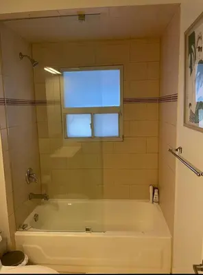 a white bath tub in a bathroom with a window at 2 Bed Apartment in DT Toronto with Free Parking in Toronto