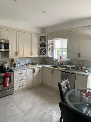 a kitchen with white cabinets and a glass table at Cozy House in Richmond Hill