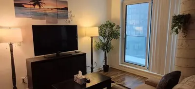 a living room with a flat screen tv and a couch at Liberty Village Condo Lake and BMO Field View in Toronto