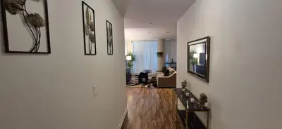 a living room with white walls and a hallway with a couch at Liberty Village Condo Lake and BMO Field View in Toronto