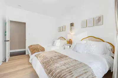two beds in a bedroom with white walls and wooden floors at Modern 3BR Home in Stouffville | Quiet & Spacious in Aurora