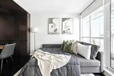a bedroom with a bed and a couch at Modern CityPlace Retreat King Bed & Balcony in Toronto