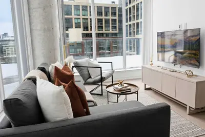 a living room with a gray couch and a table at Stunning 2BR Downtown Condo w Huge Private Patio in Toronto
