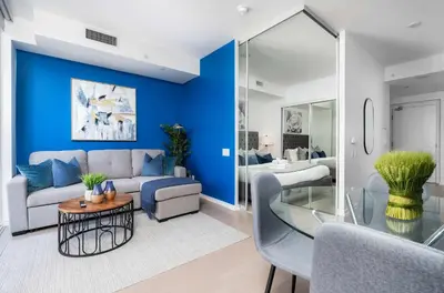 a living room with a blue accent wall at Designer 1BR Condo Entertainment District in Toronto