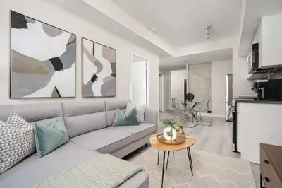 a living room with a couch and a table at Modern CityPlace 2BR Balcony & Free Parking in Toronto