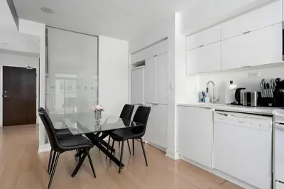 a kitchen with a glass table and black chairs at Modern CityPlace Sky Home 2BR 2BA & Balcony in Toronto
