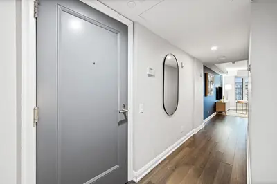 a hallway with a door and a mirror at Sleek Yorkville King Suite Sleeps 5 DT in Toronto