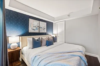 a bedroom with a large bed with blue walls at Sleek Yorkville King Suite Sleeps 5 DT in Toronto