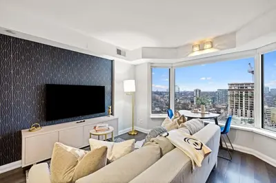 a living room with a large couch and a tv at Sleek Yorkville King Suite Sleeps 5 DT in Toronto