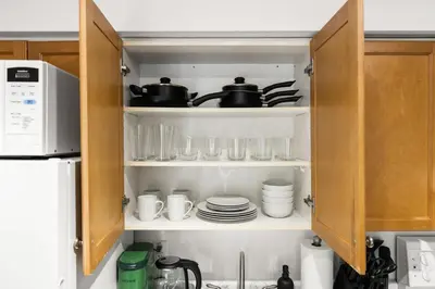 a kitchen cabinet filled with dishes and utensils at Downtown Oasis Sleek Suite by Yonge Dundas Sq in Toronto