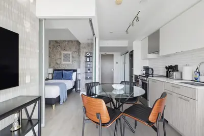 a kitchen and living room with a table and chairs at Stunning Family-Friendly Parking & City Views in Toronto