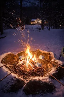 a fire pit in the snow at night at Waterfront Muskoka Cottage with FirePit, BBQ and Canoes in Bracebridge