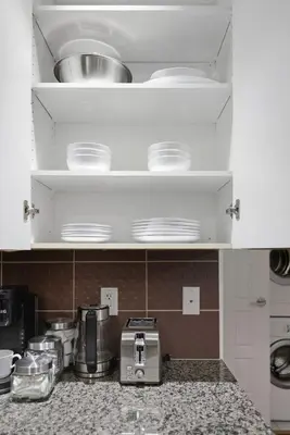 a kitchen with white cabinets and a counter top at Cozy 1BR Condo w Private Patio for Morning Coffee in Toronto