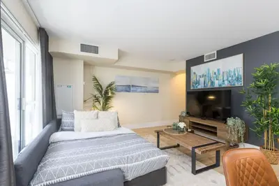 a living room with a couch and a flat screen tv at Modern 1BR Retreat with Balcony & Parking in Toronto