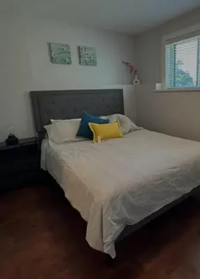 a bedroom with a bed with a yellow pillow on it at Cozy 2 bedroom ice fishing&skiing in Georgina