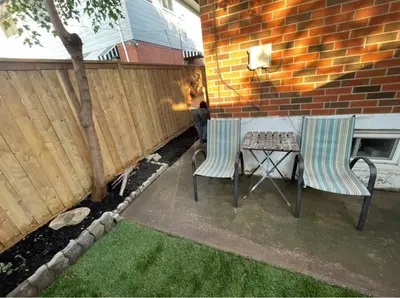 a patio with two chairs and a table and a fence at 1 Bedroom Basement with parking and Backyard in Hamilton