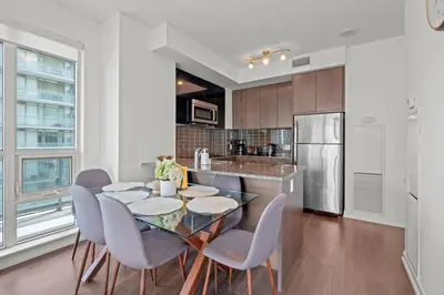 a kitchen with a table and chairs and a refrigerator at Cozy 2 Bedroom Condo in Dunfield Ave Downtown Toronto in Toronto