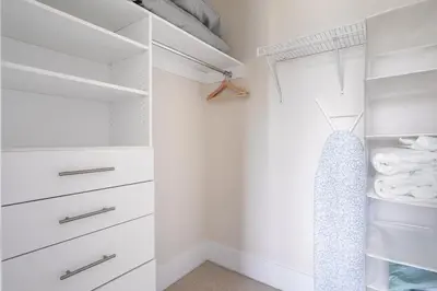 a walk in closet with white cabinets and drawers at Paradise Birds 1 Bedroom Condo in Downtown Toronto in Toronto